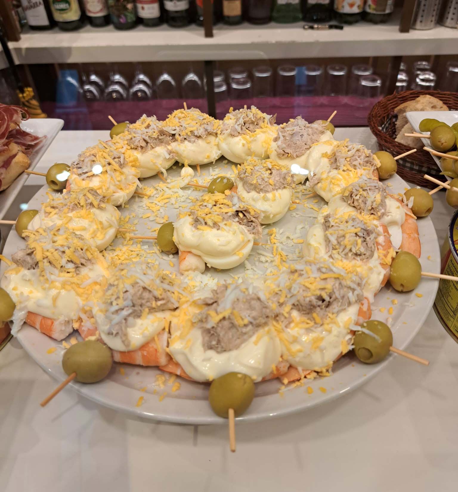 Un plato de comida con aceitunas en palitos sobre una mesa.