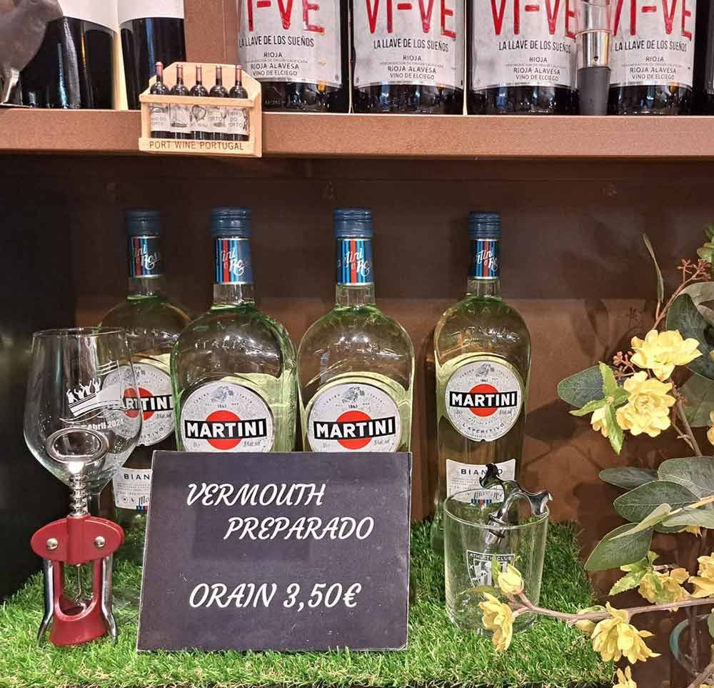 Varias botellas de martini están alineadas en un estante.