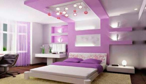 Un dormitorio con paredes moradas y una cama blanca.