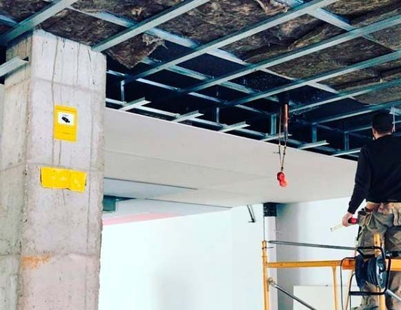 Un hombre está trabajando en el techo de un edificio.