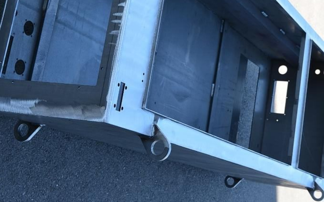 Cadre industriel en métal gris foncé avec de multiples ouvertures et des boucles en bas