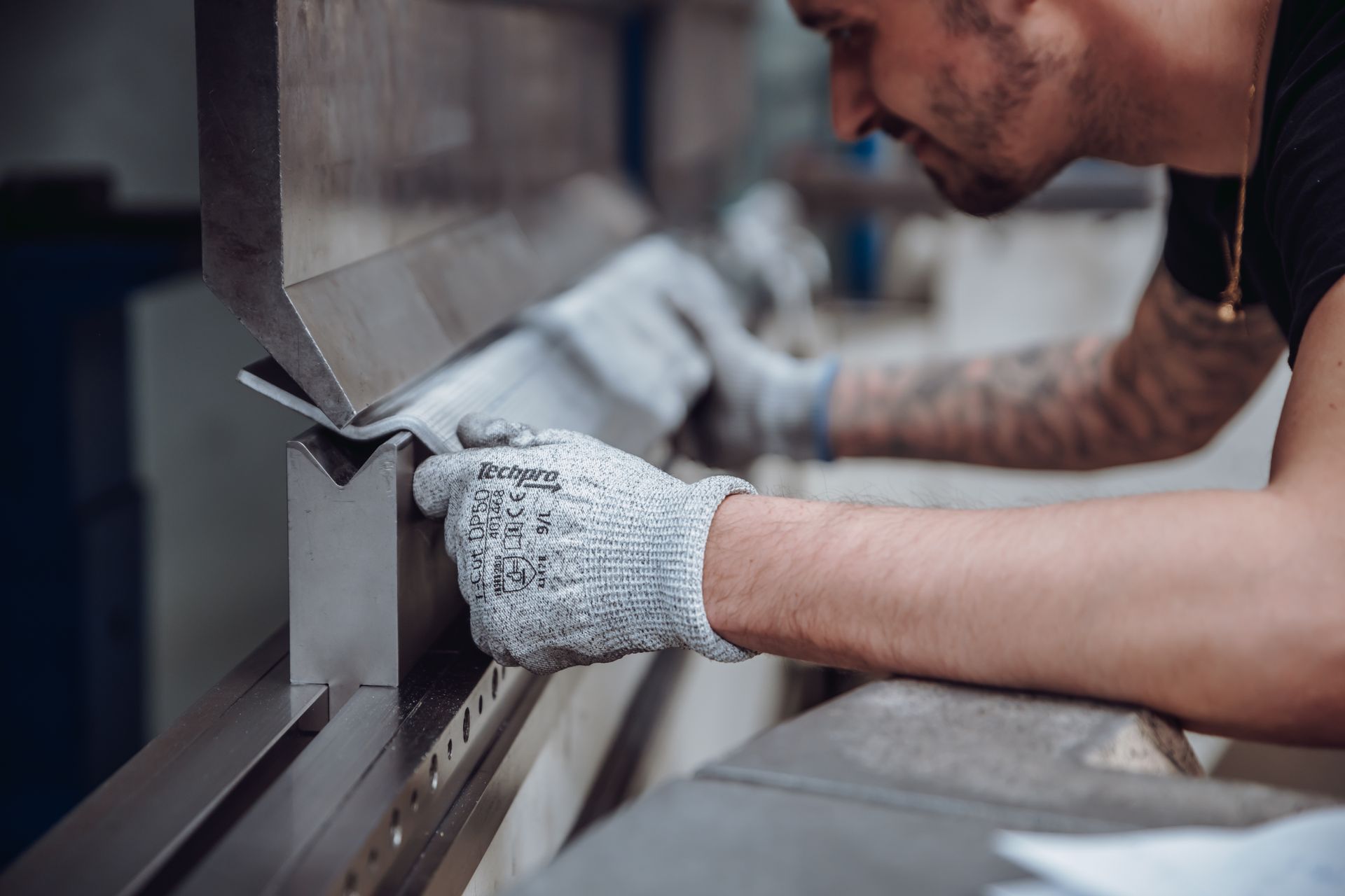 Un homme utilise une machine industrielle pour plier du métal