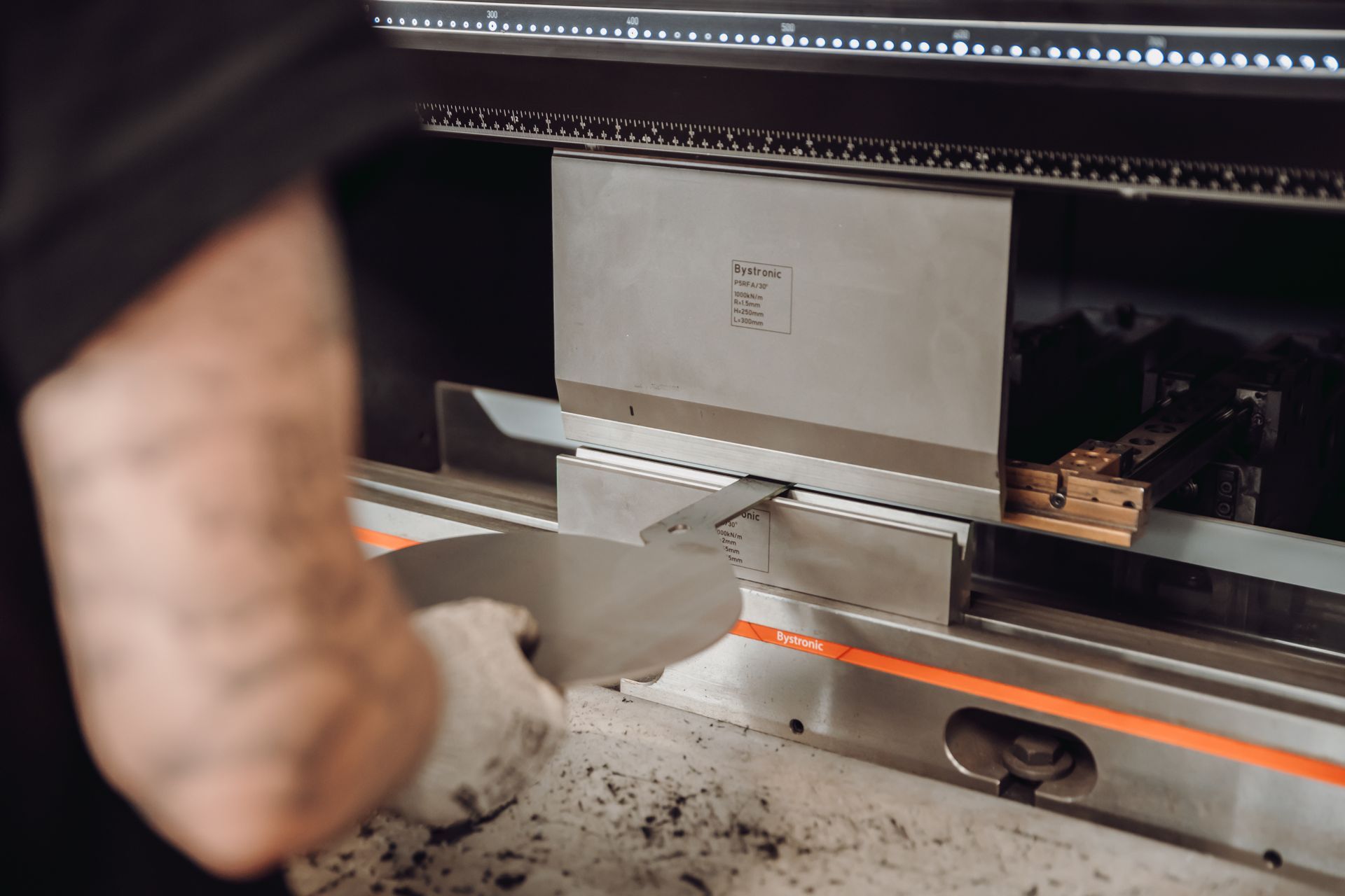 Métallurgiste pliant une tôle à l'aide d'une presse industrielle