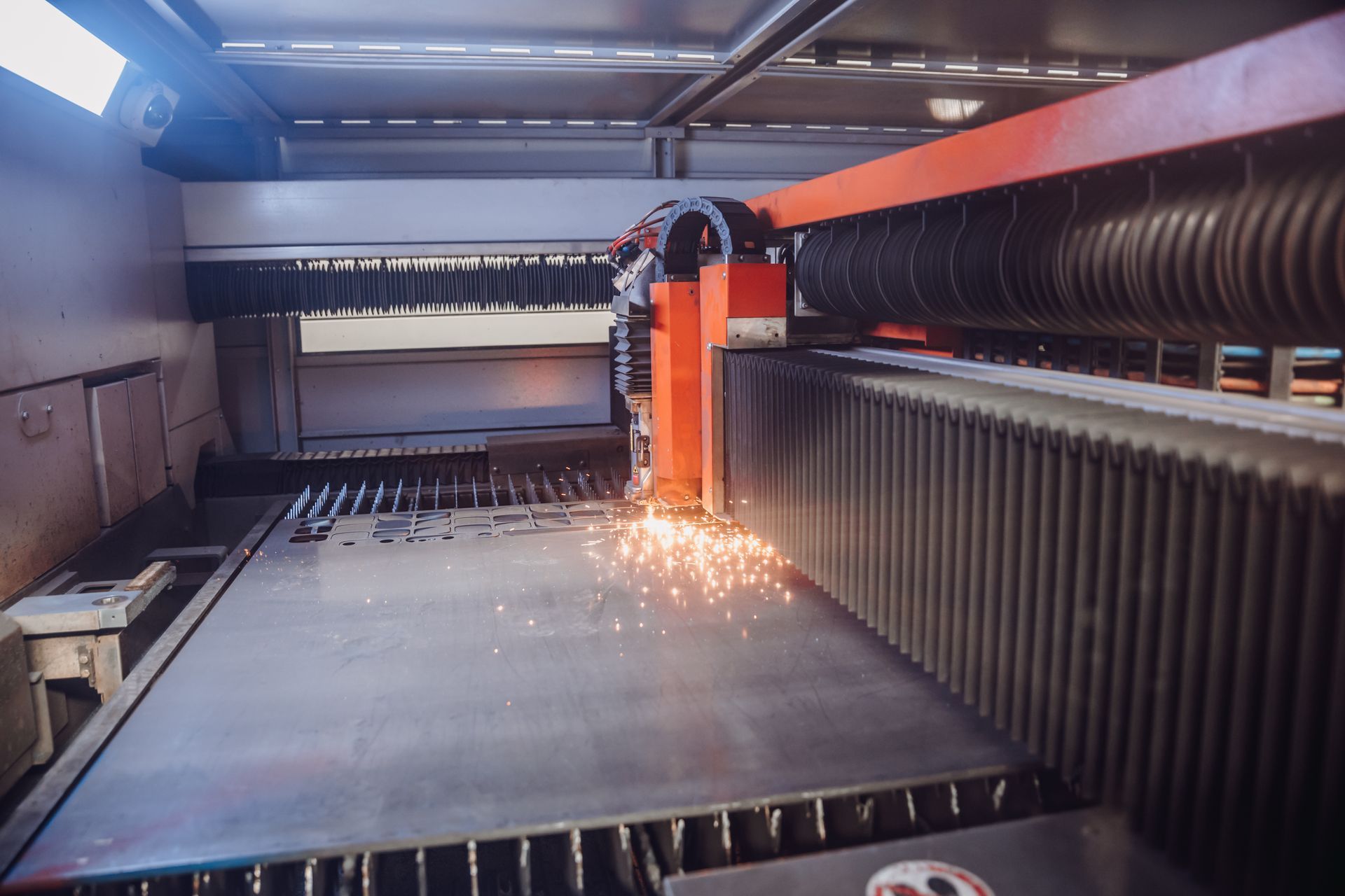 Découpeuse laser en fonctionnement, découpant une tôle métallique