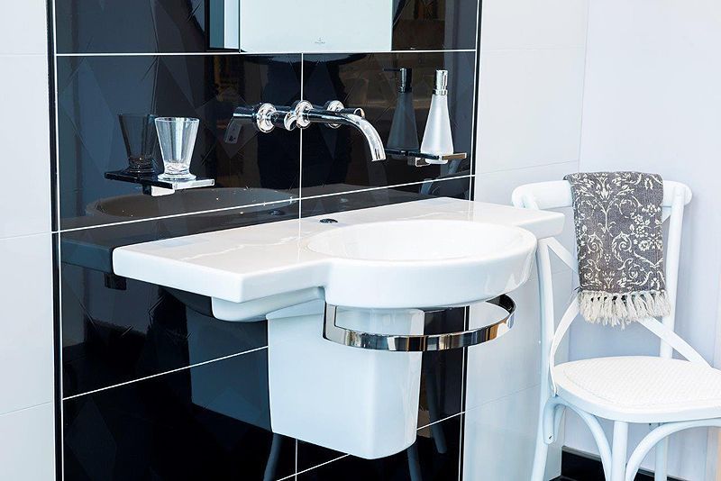 Ein Badezimmer mit Waschbecken, Stuhl und Spiegel