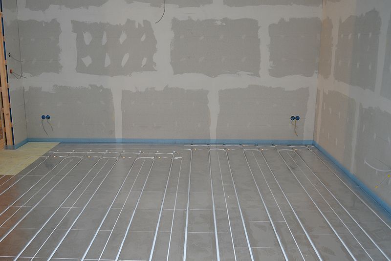 Ein Raum mit grauem Boden und weißer Wand