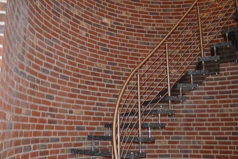 Eine Wendeltreppe, die zu einer Backsteinmauer hinaufführt.