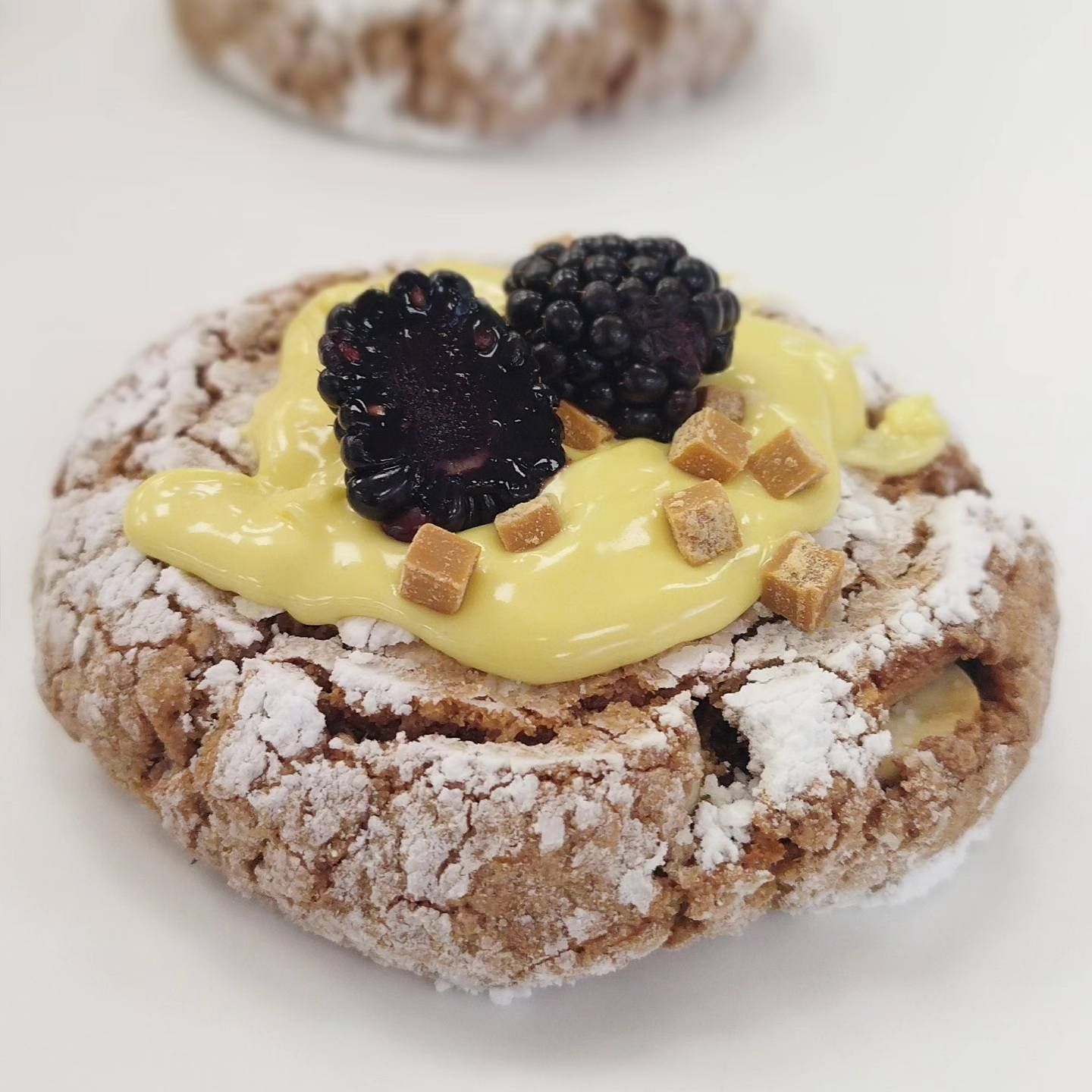 Una galleta con azúcar en polvo y bayas encima.
