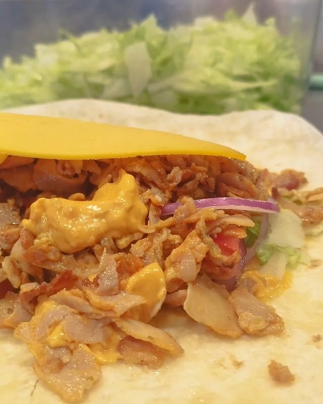 Un primer plano de una tortilla con carne y queso.