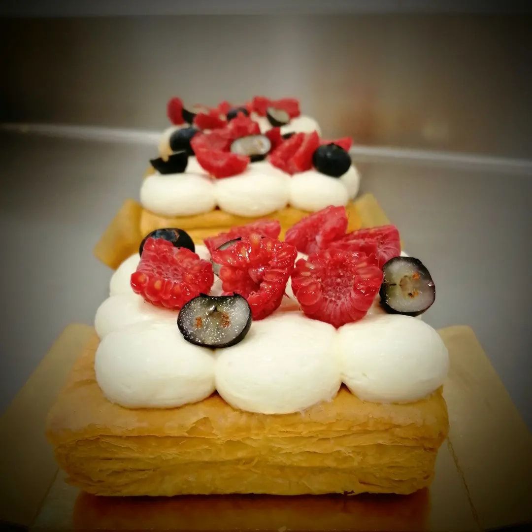 Un pastel con frambuesas y arándanos encima.