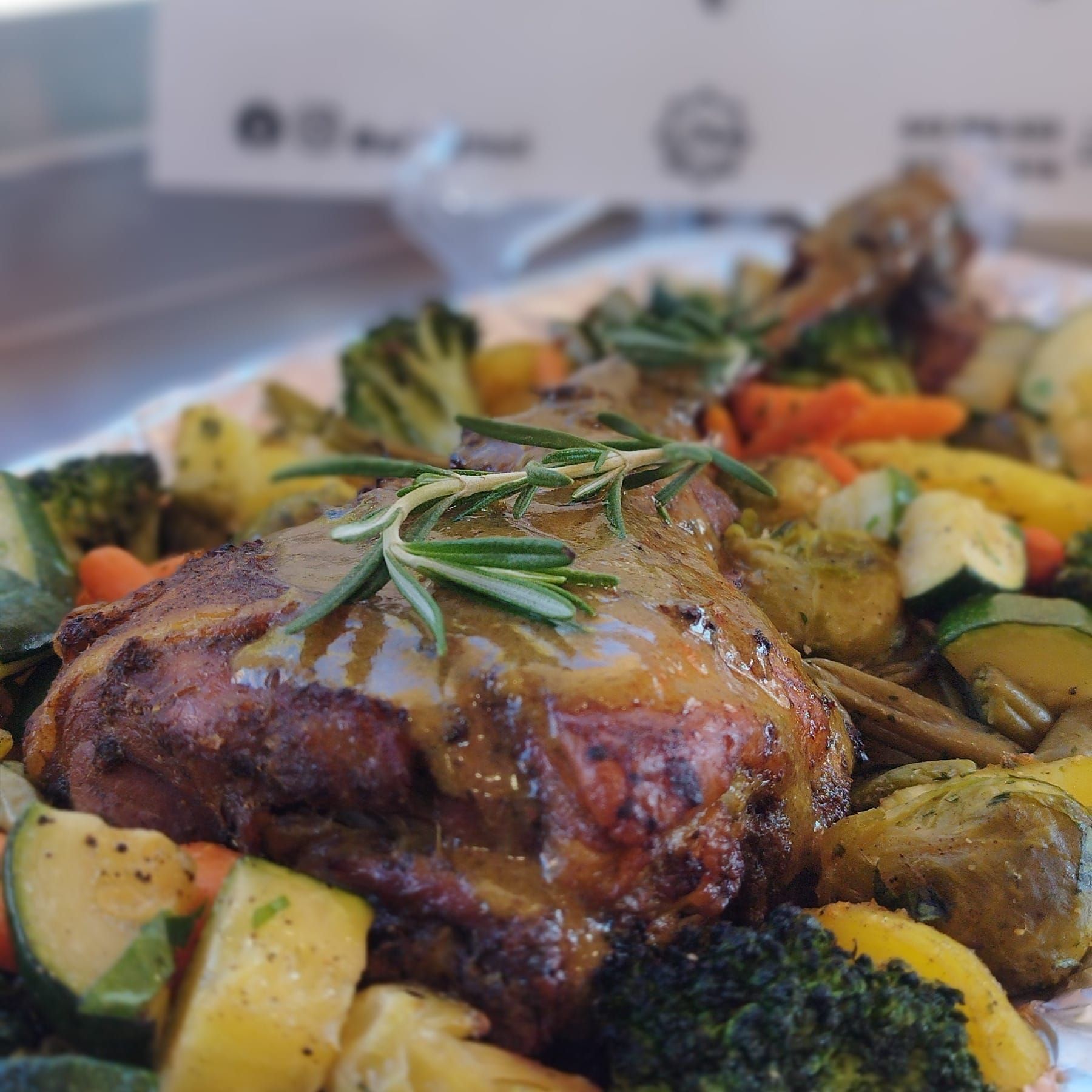 Carne asada con verduras, adornada con romero.