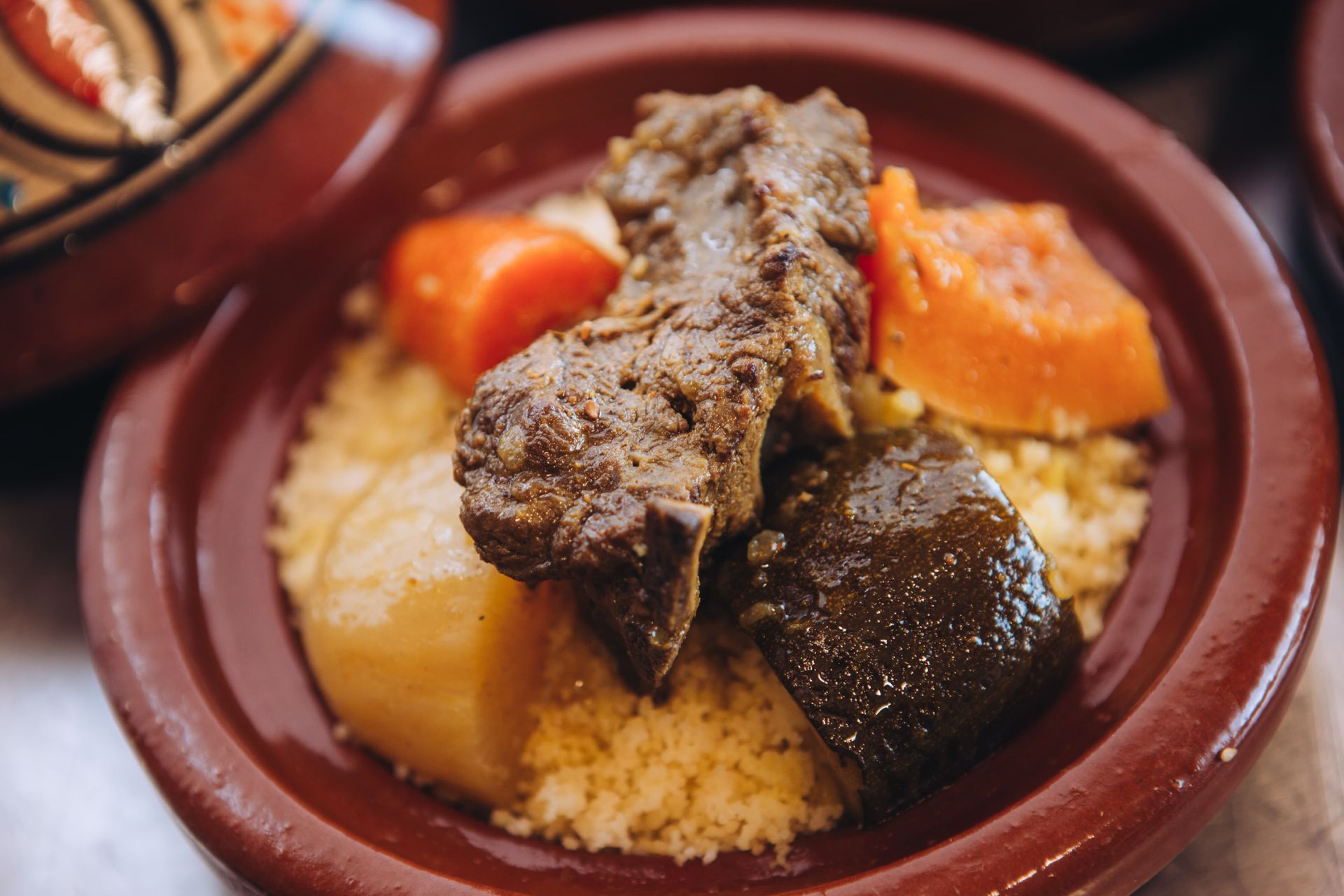 Un primer plano de un plato de comida con carne y verduras sobre una mesa.