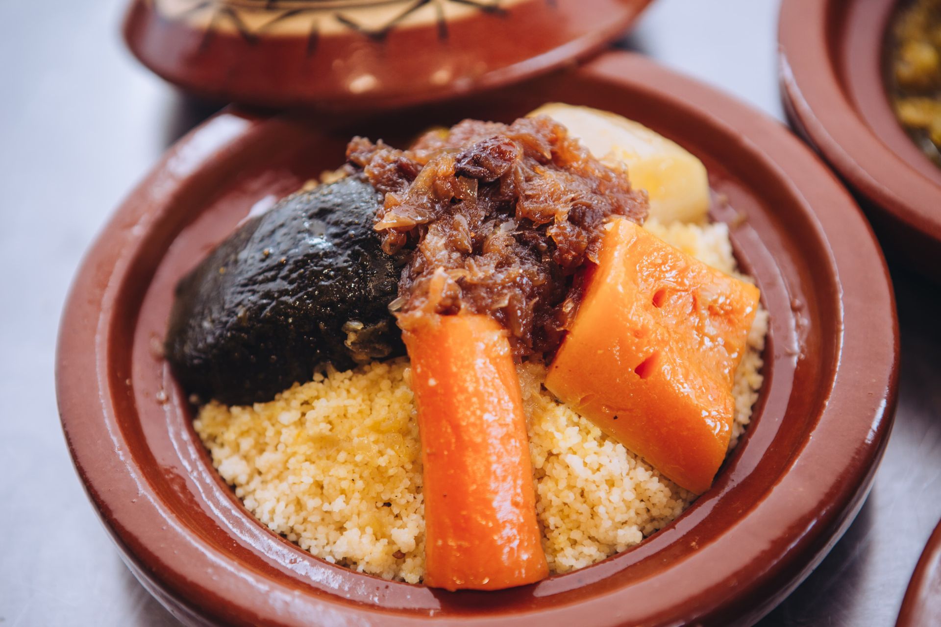 Un primer plano de un plato de comida con cuscús y zanahorias en una mesa.