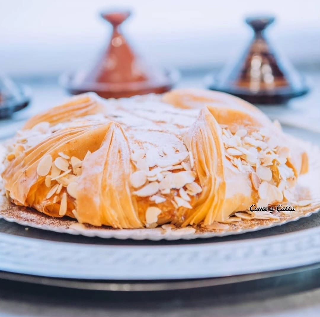 Un primer plano de un pastel con almendras encima.