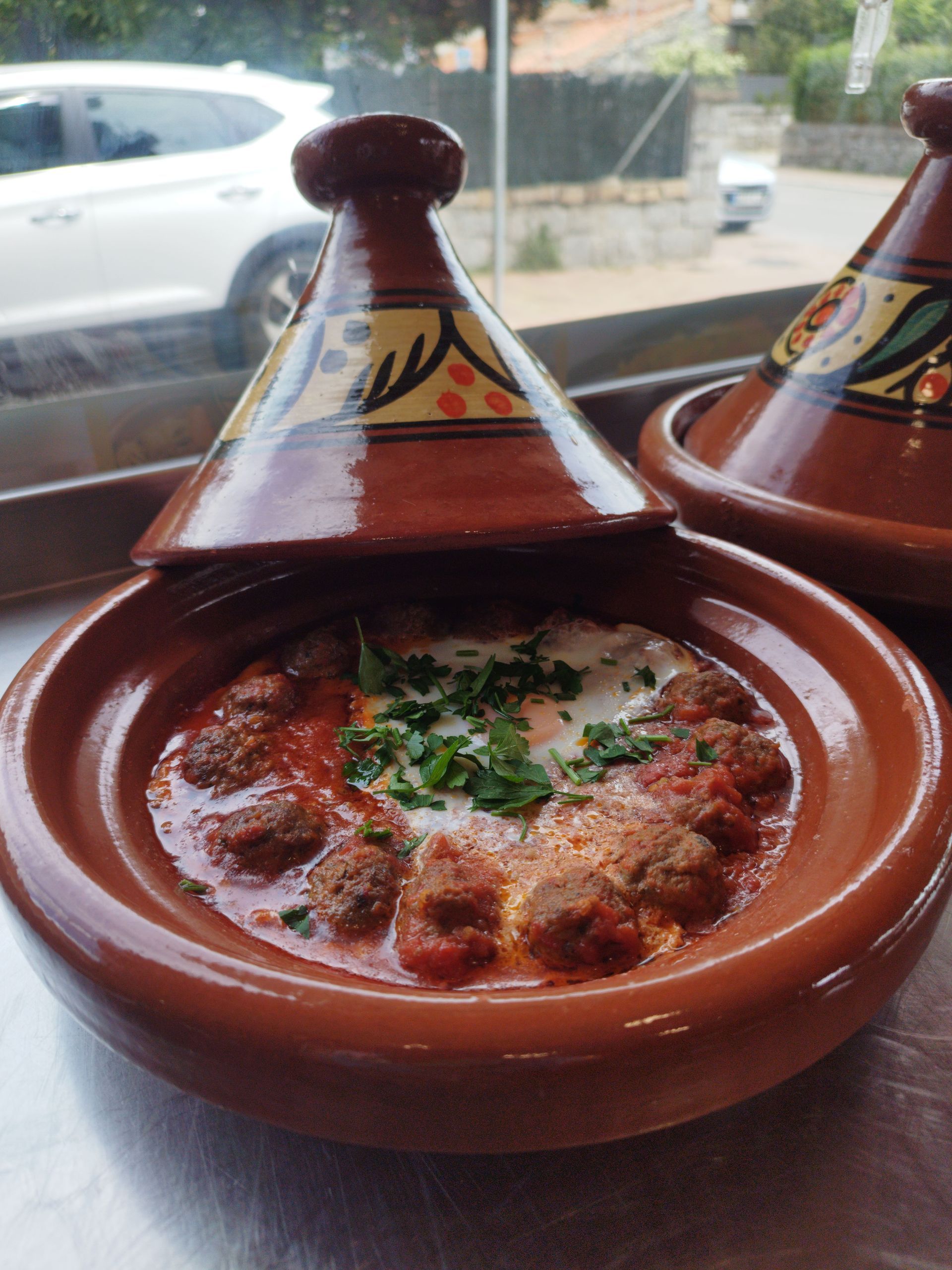 Un tazón de comida con albóndigas y huevos en una mesa.