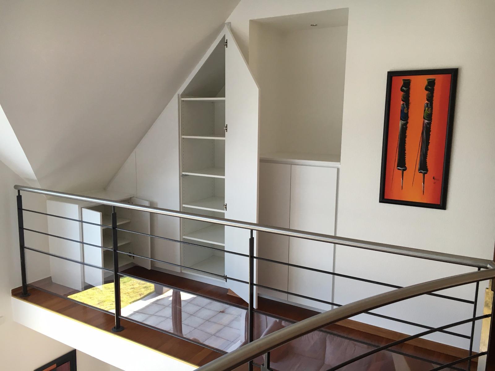 Placard laqué blanc sous mansarde dans mezzanine