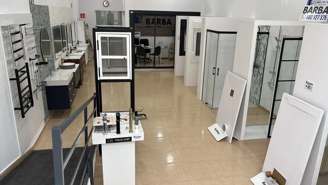 Sala de exposición con escaparates y puertas dispuestos en filas sobre un suelo de baldosas.