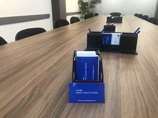 Una mesa de conferencias de madera con una tarjeta con el nombre en ella