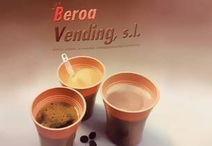 Tres tazas de café, una con helado y una cuchara, sobre un fondo borroso de una máquina expendedora.