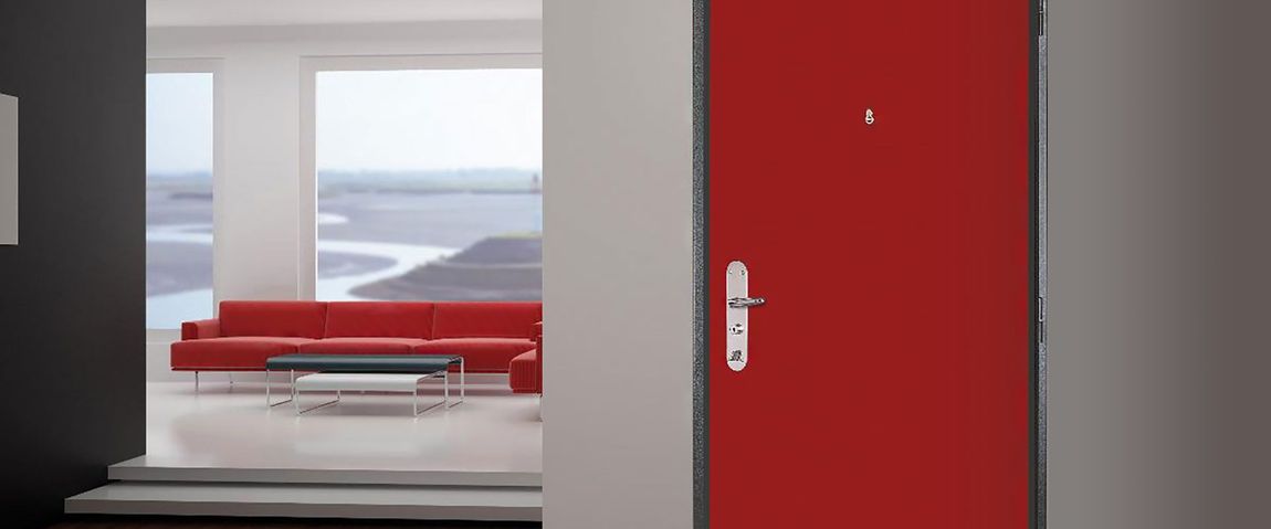 Une porte rouge s'ouvre sur un salon moderne avec un canapé rouge et une fenêtre offrant une belle vue.