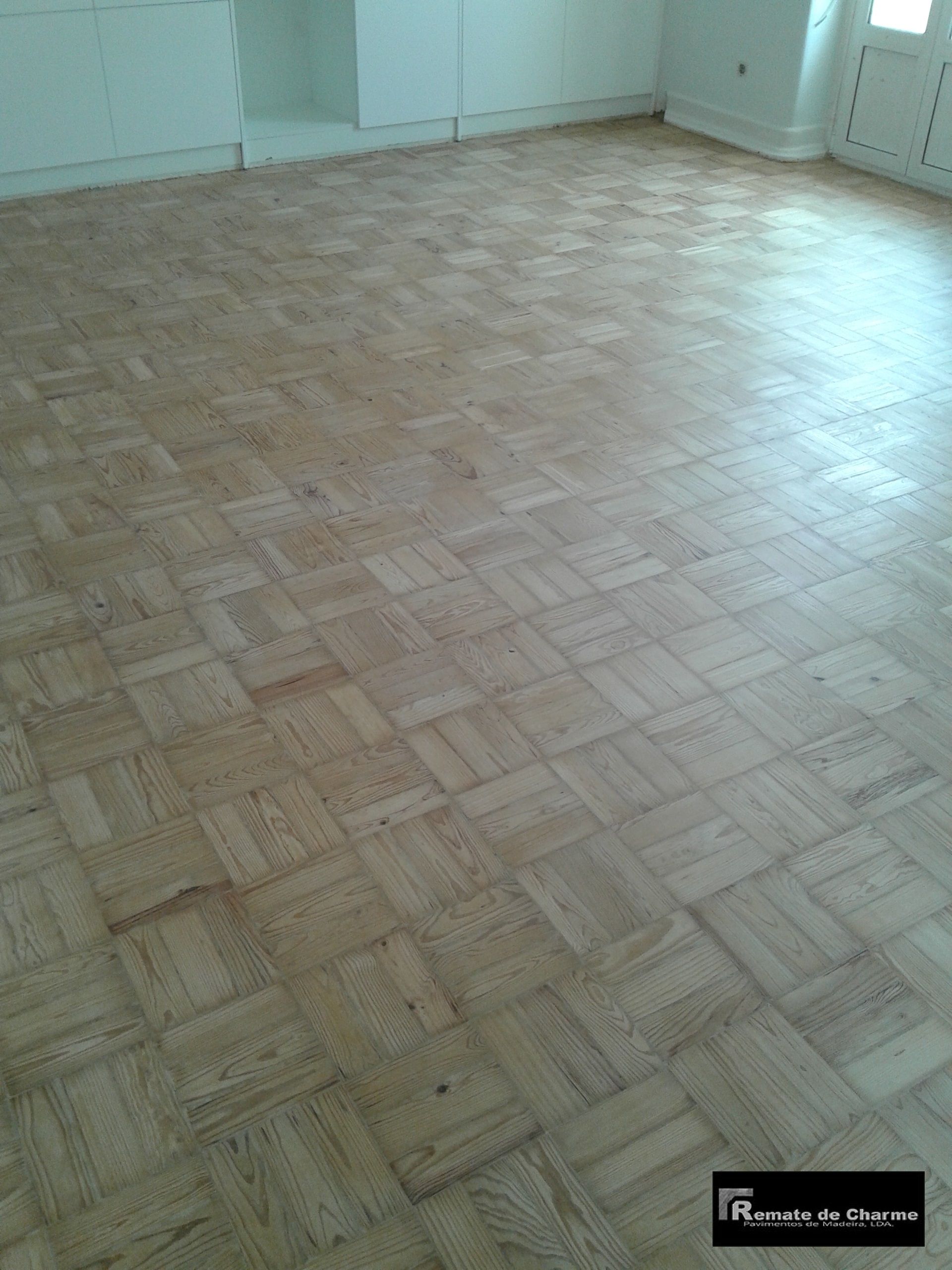 Piso de parquet de madeira em uma sala com paredes brancas.