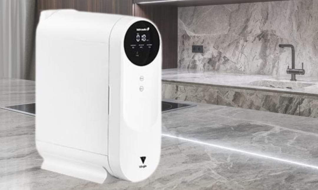 Un filtro de agua blanca está sobre un mostrador en una cocina.