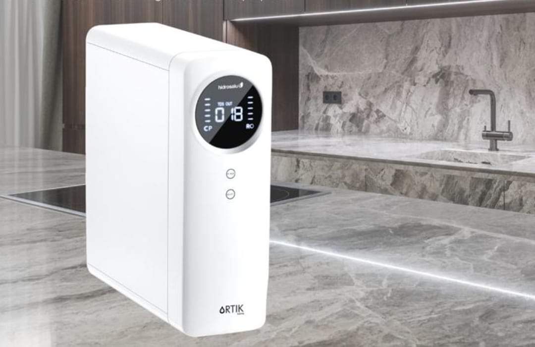 Un filtro de agua blanca está sobre un mostrador en una cocina.