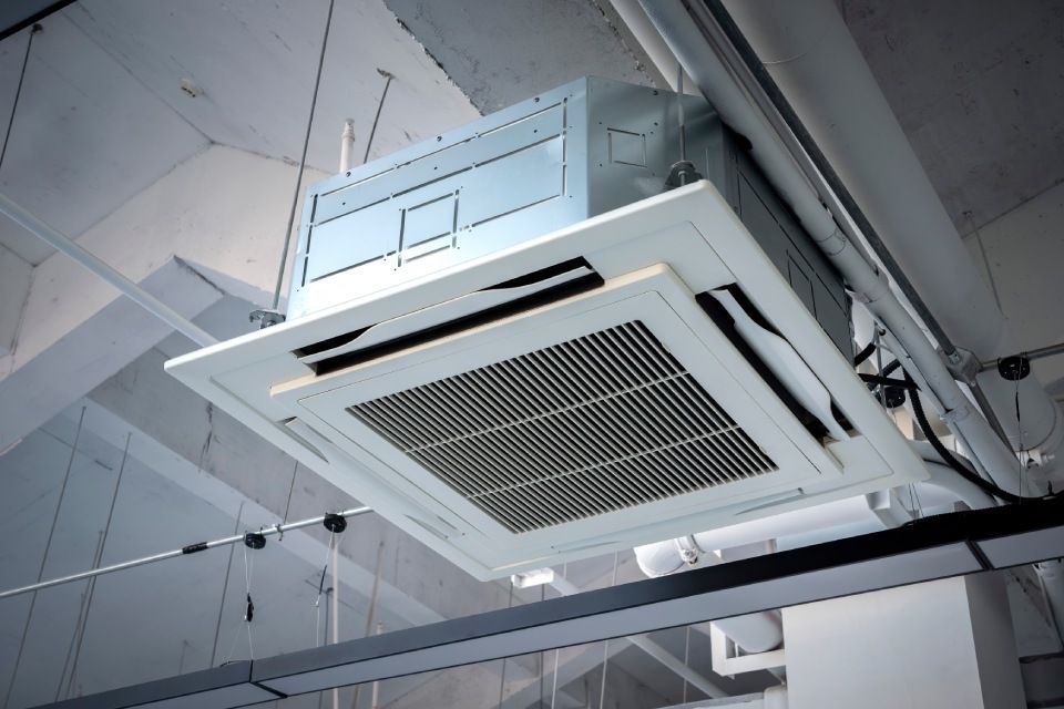 Eine an der Decke montierte Klimaanlage hängt von der Decke eines Gebäudes.