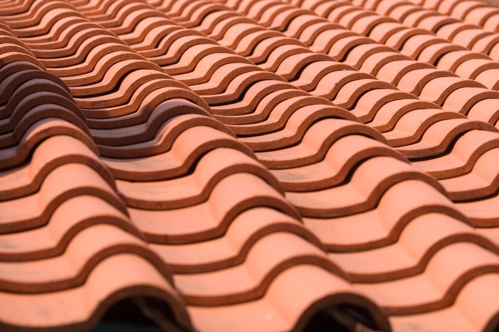 Close-up of terracotta roof tiles with a repeating wavy pattern