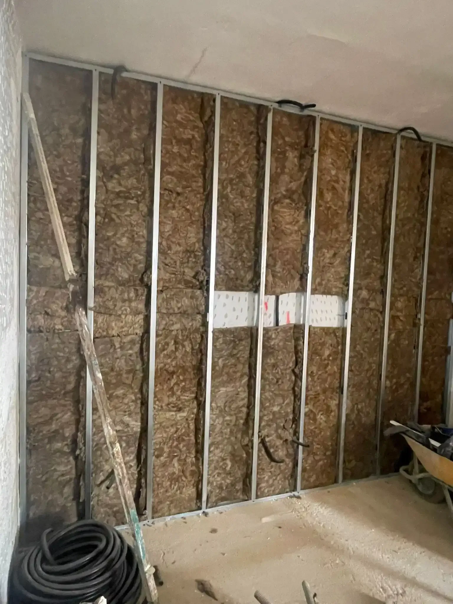 Pared interior en proceso de renovación con aislamiento expuesto