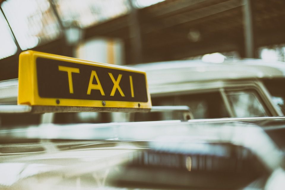 Panneau TAXI jaune sur le toit d'une voiture dans une rue de la ville