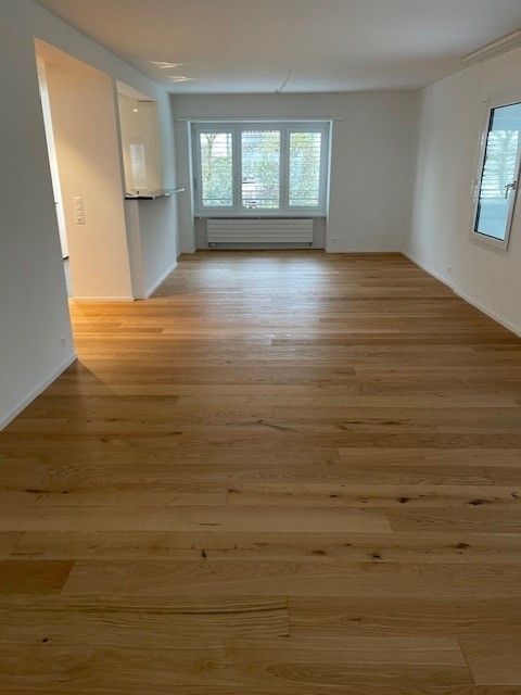 Eine Frau reinigt den Boden mit einer Sprühflasche und einem Lappen.