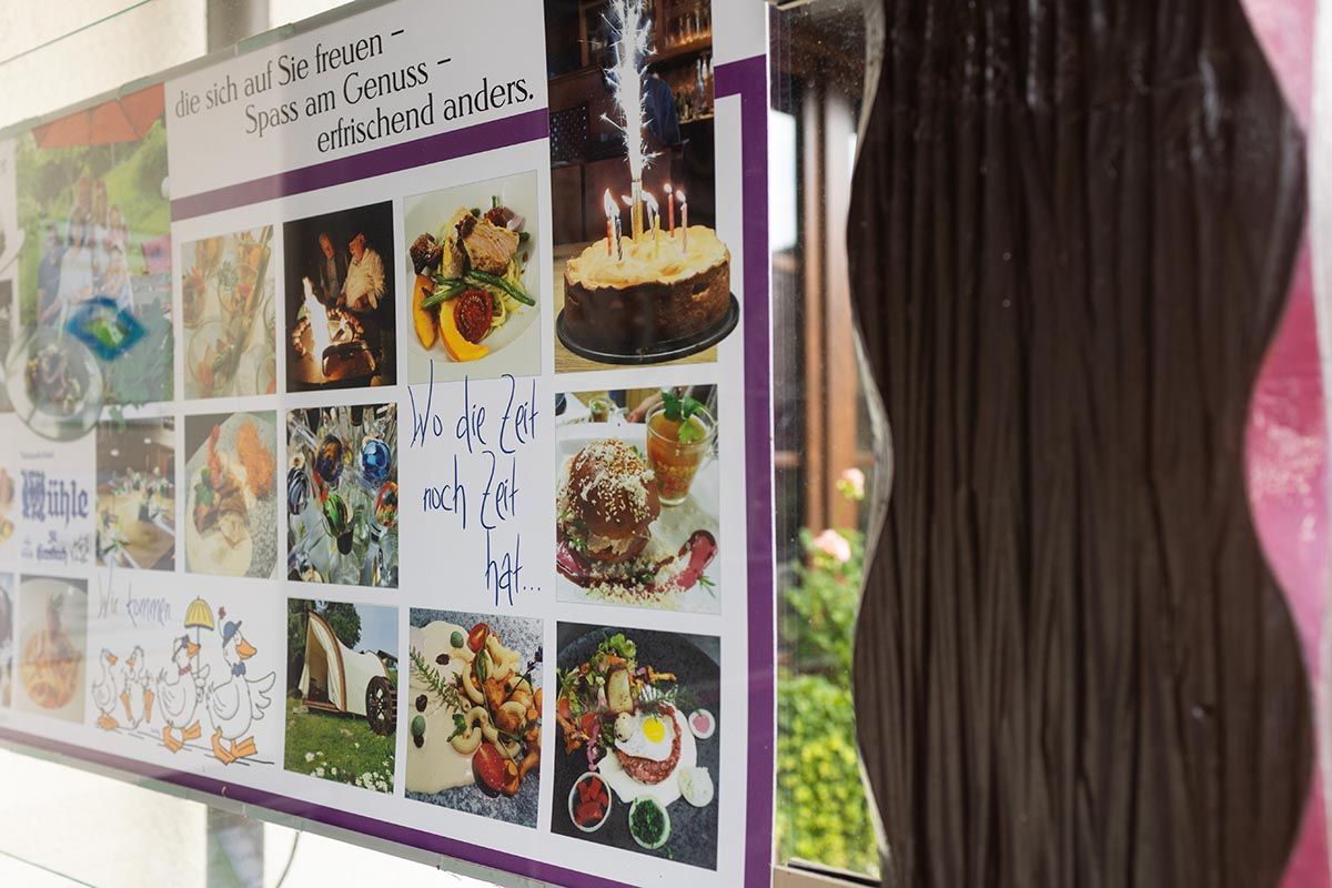 Farbenfrohes Poster mit Kuchen und Desserts neben einem Fenster mit dunklen Vorhängen