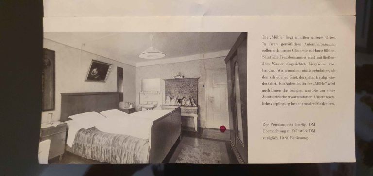 Schwarz-Weiß-Foto eines Schlafzimmers mit Bett, Kleiderschrank und Kamin neben einem Textfeld.