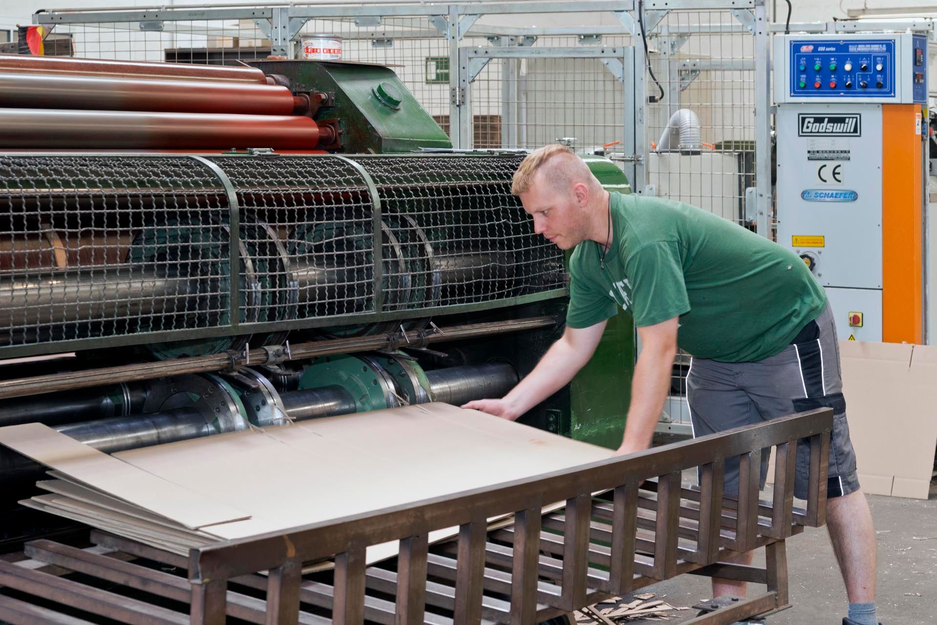 Ein Mann legt Verpackungskartons zusammen.