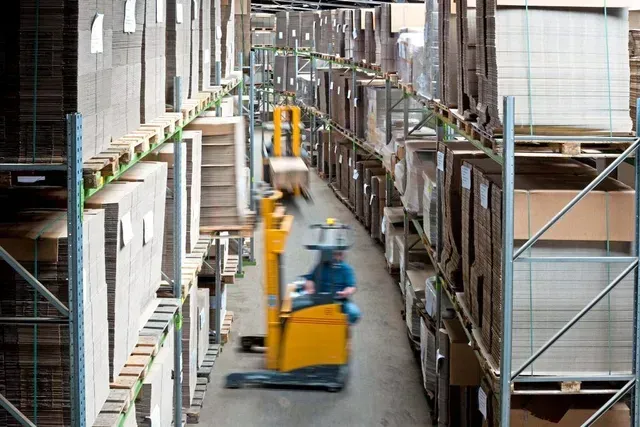 Ein Mann fährt einen gelben Gabelstapler in einer Lagerhalle Wortmann Verpackungen GmbH & Co. KG.