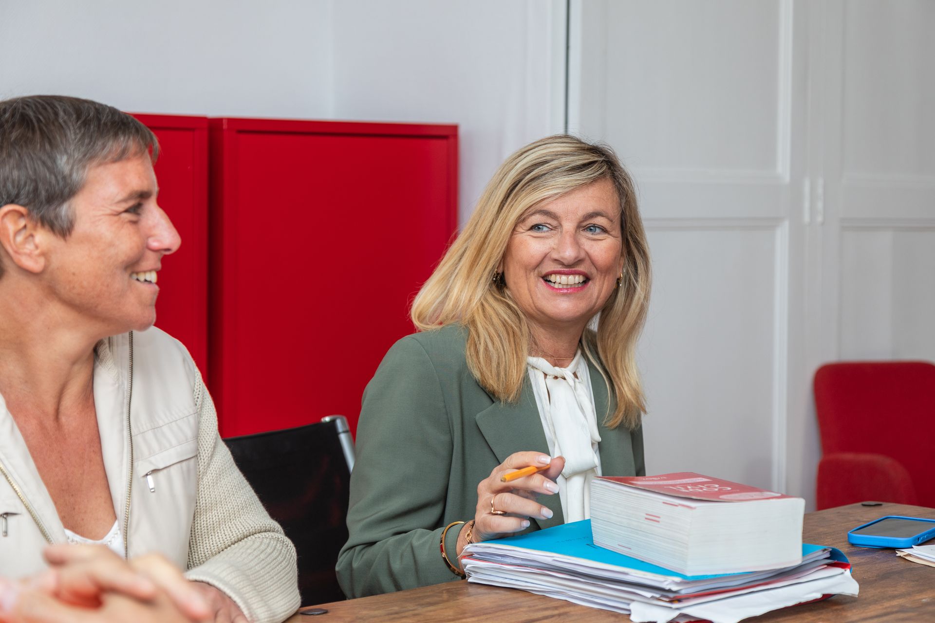Une femme blonde sourit à une autre femme