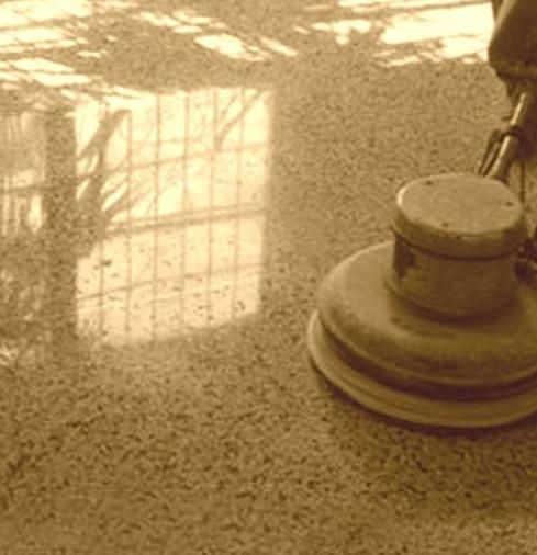 Una persona está puliendo un piso de mármol con una máquina.