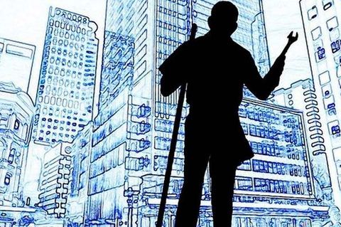 Una silueta de un hombre con muletas de pie frente a una ciudad.