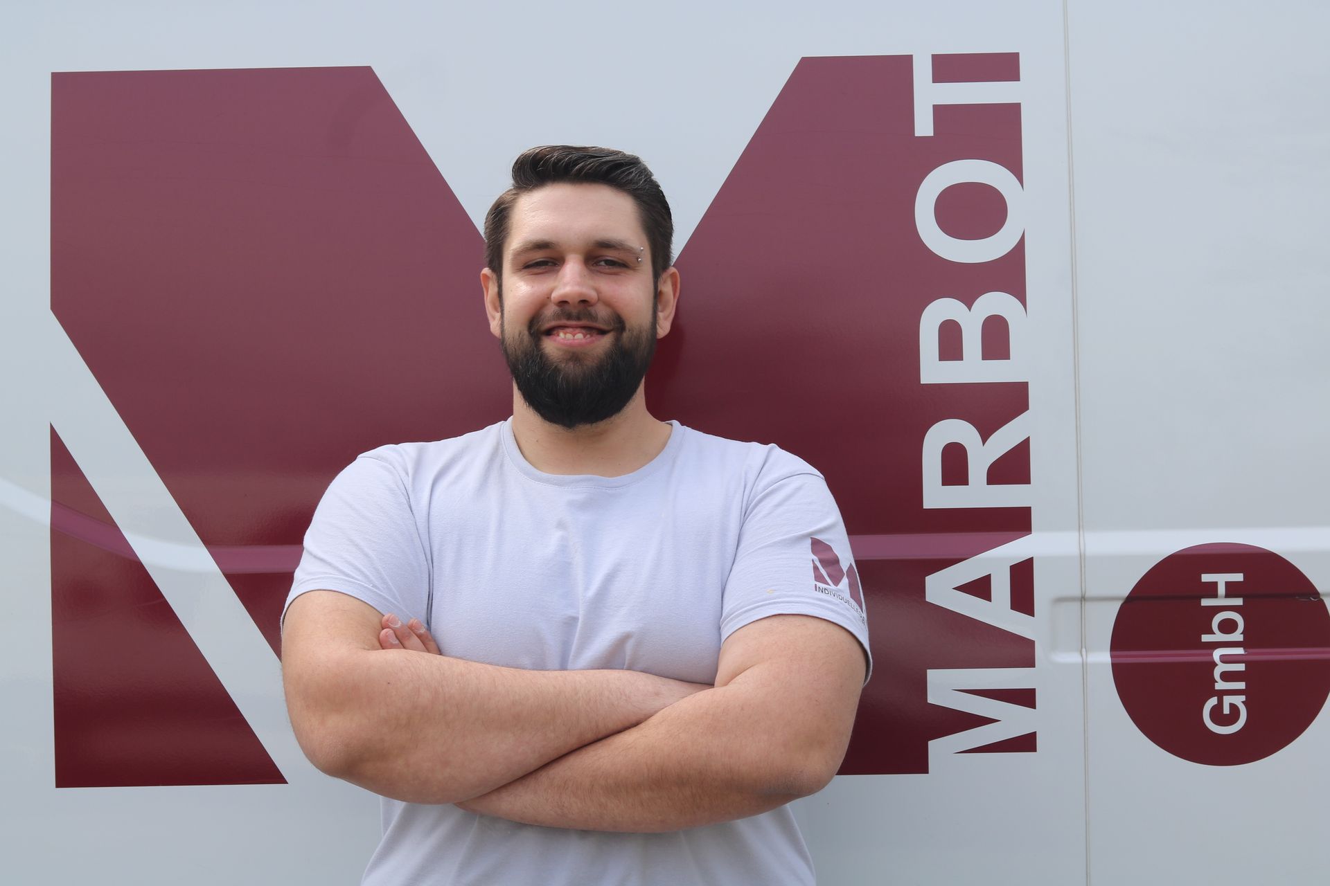 Ein Mann mit verschränkten Armen vor einem Lieferwagen mit der Aufschrift „Marbot“