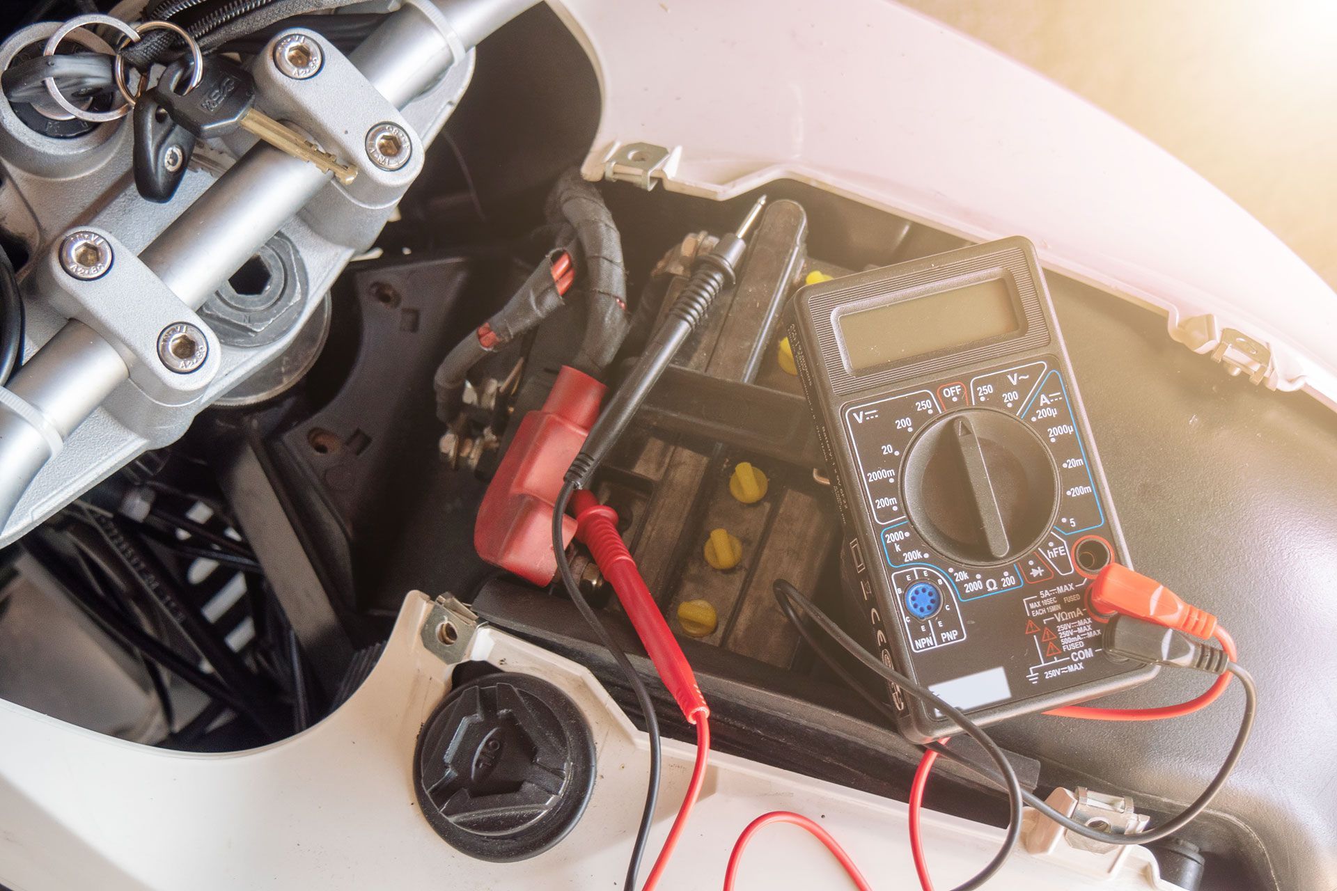 Une femme tenant un câble de démarrage noir et rouge qui montre les bornes positive et négative à utiliser comme connecteur pour stimuler le démarrage de la batterie de la voiture.