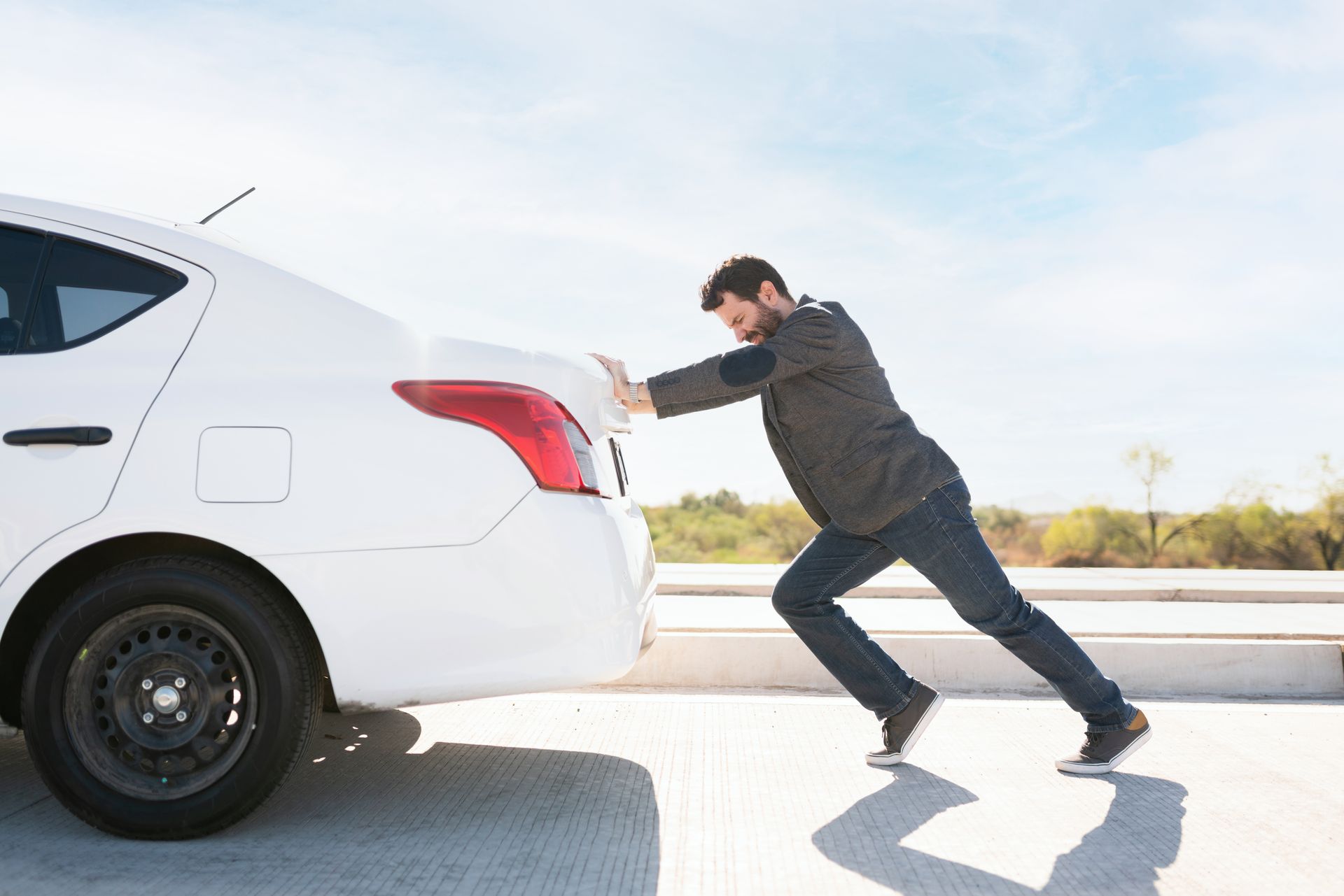 Un homme en costume pousse sa voiture