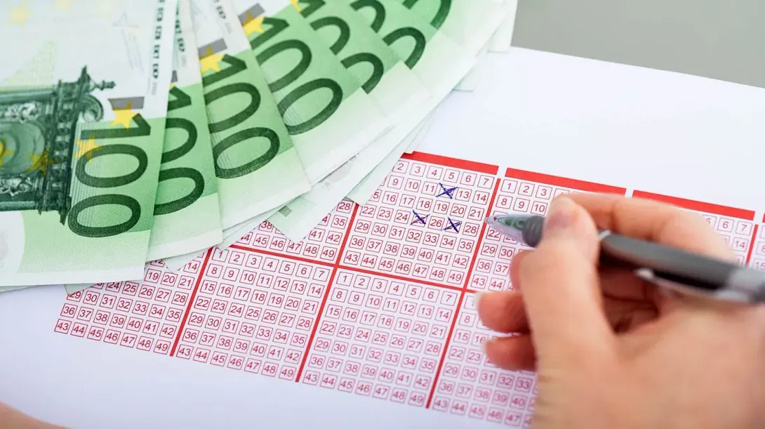 Una persona está escribiendo en un billete de lotería con un bolígrafo.