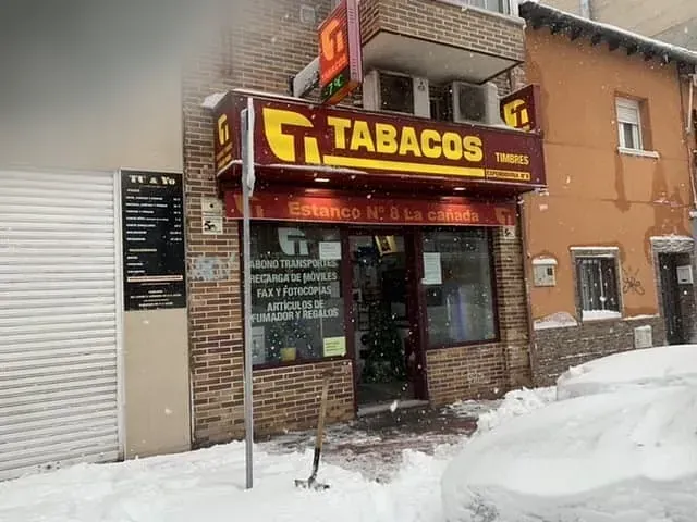 Una tienda llamada tabacos está cubierta de nieve