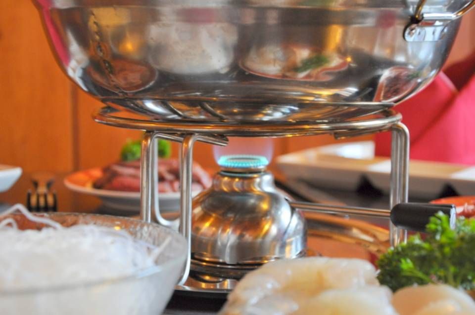 Un bol de nouilles est posé sur une table à côté d'un bol de crevettes.