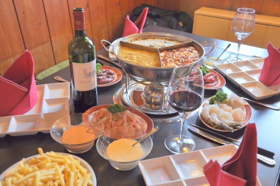 Une table sur laquelle sont posées des assiettes de nourriture et une bouteille de vin.