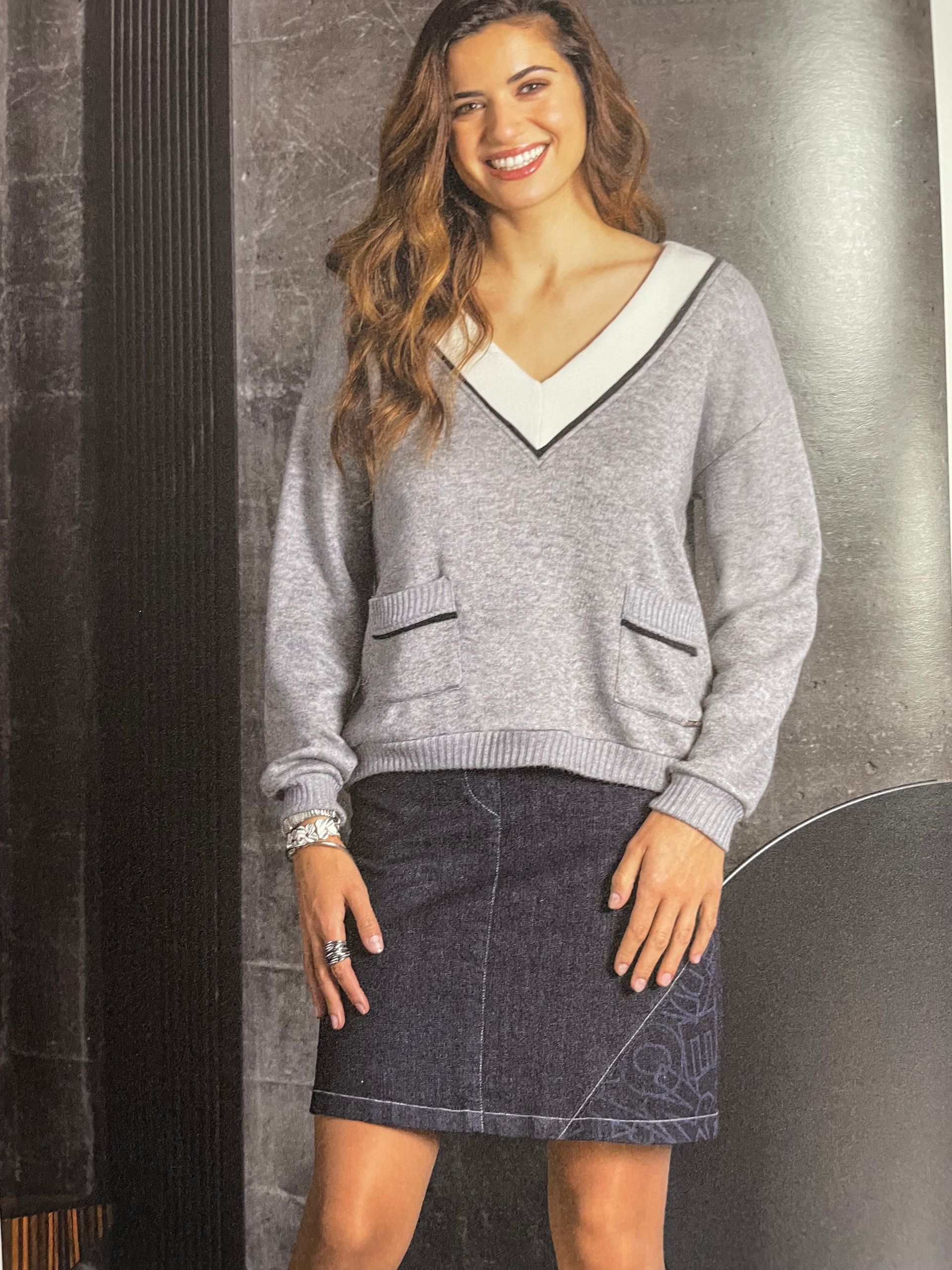 Pull col V gris avec poches et jupe en jean noire