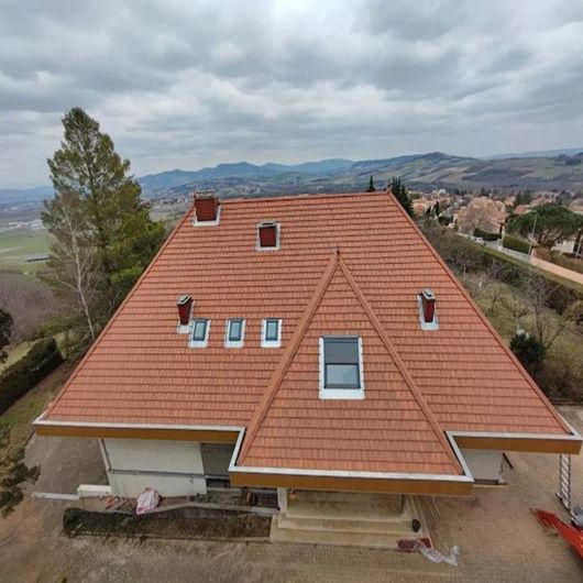 Vue aérienne d'une maison au toit de tuiles orange.