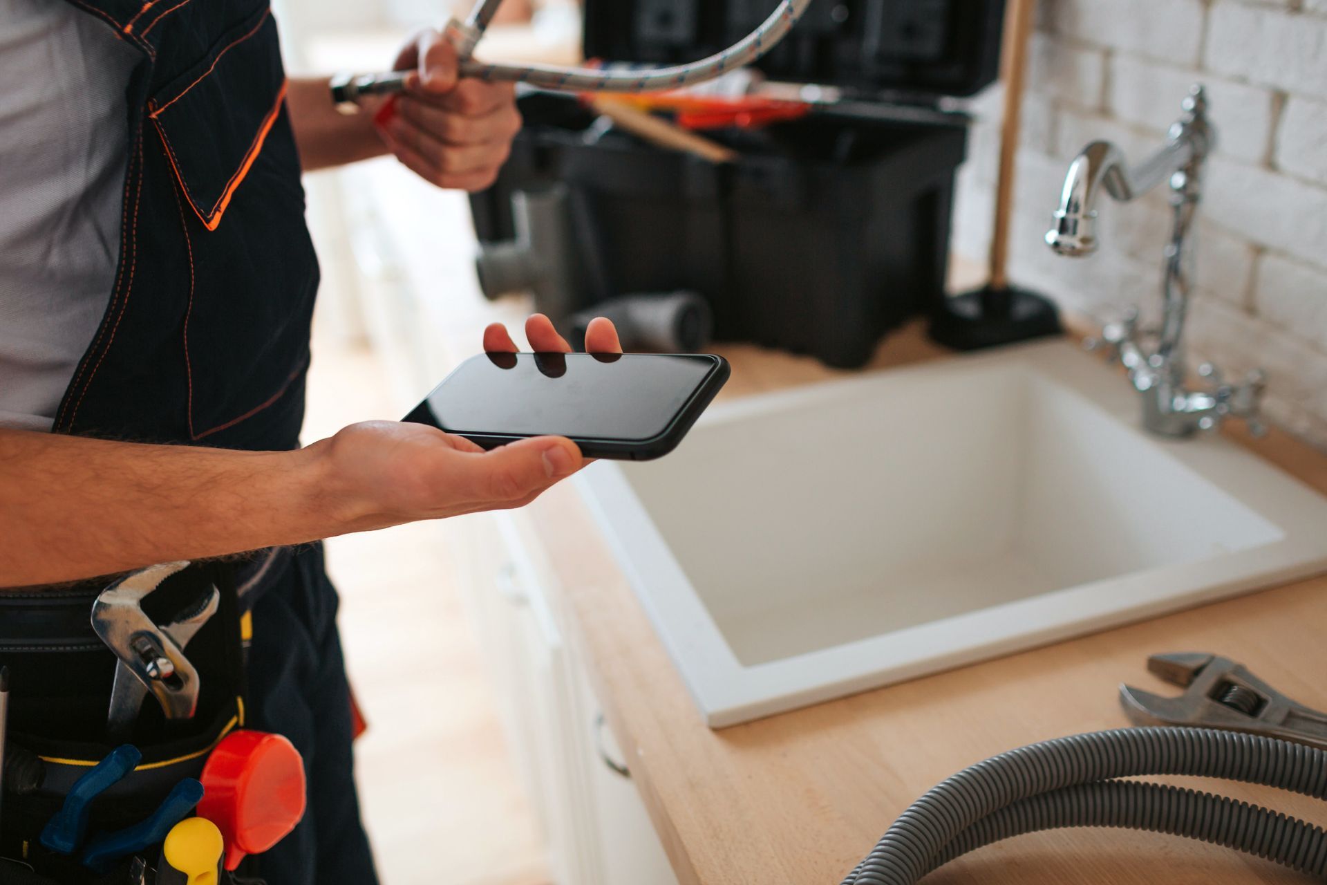 Un plombier-chauffagiste tenant un téléphone dans sa main