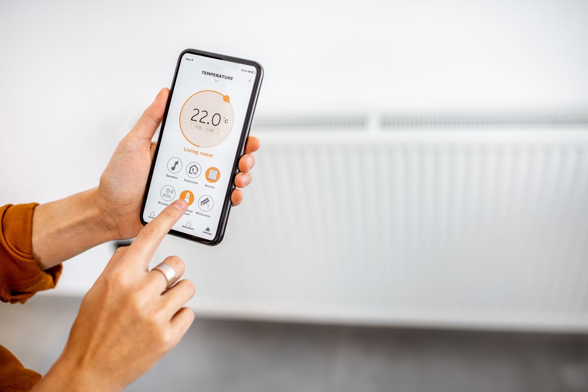 Une personne qui pilote la température de son radiateur à distance